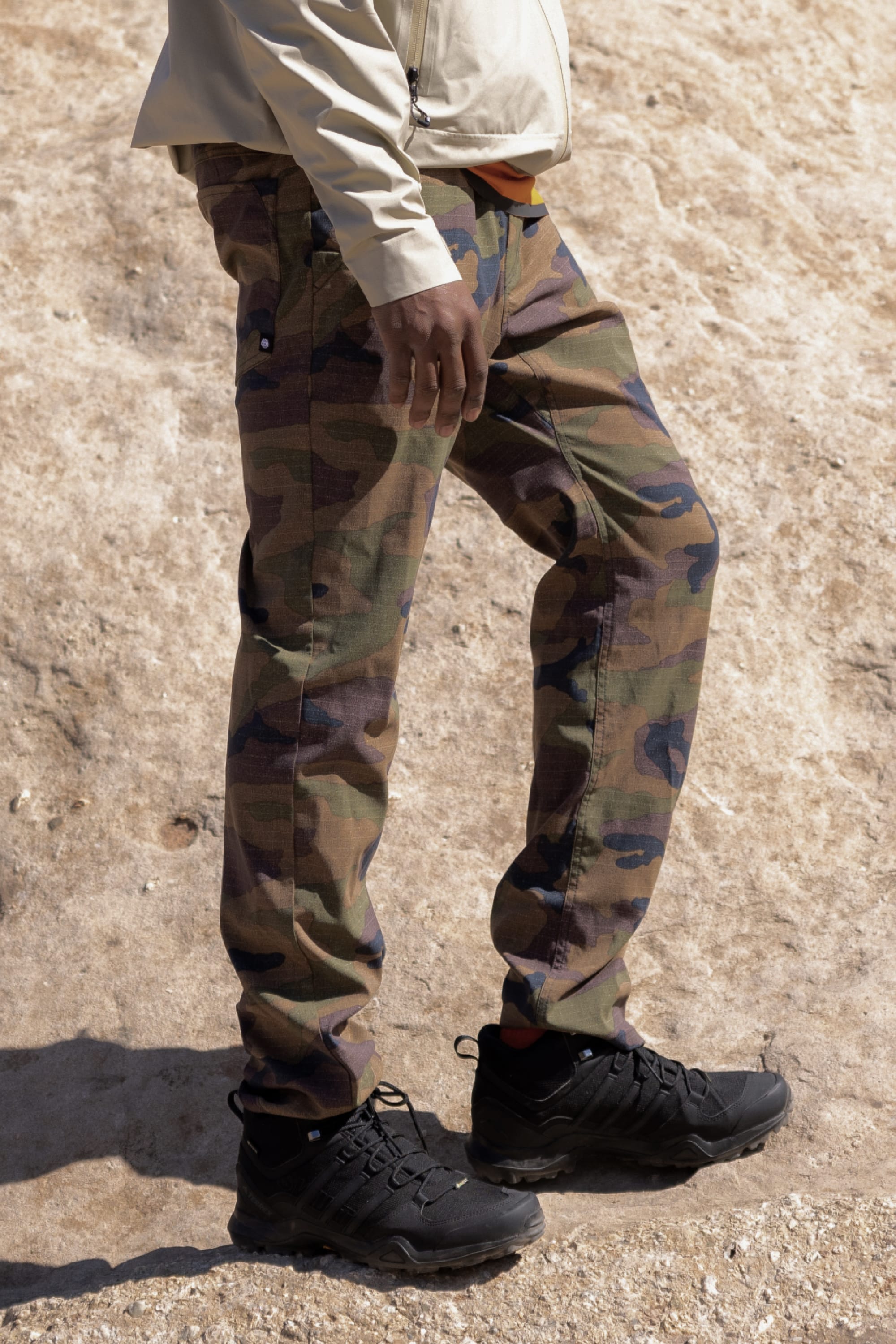 A person wearing 686 Everywhere® Pant - Slim Fit in camouflage and black shoes.