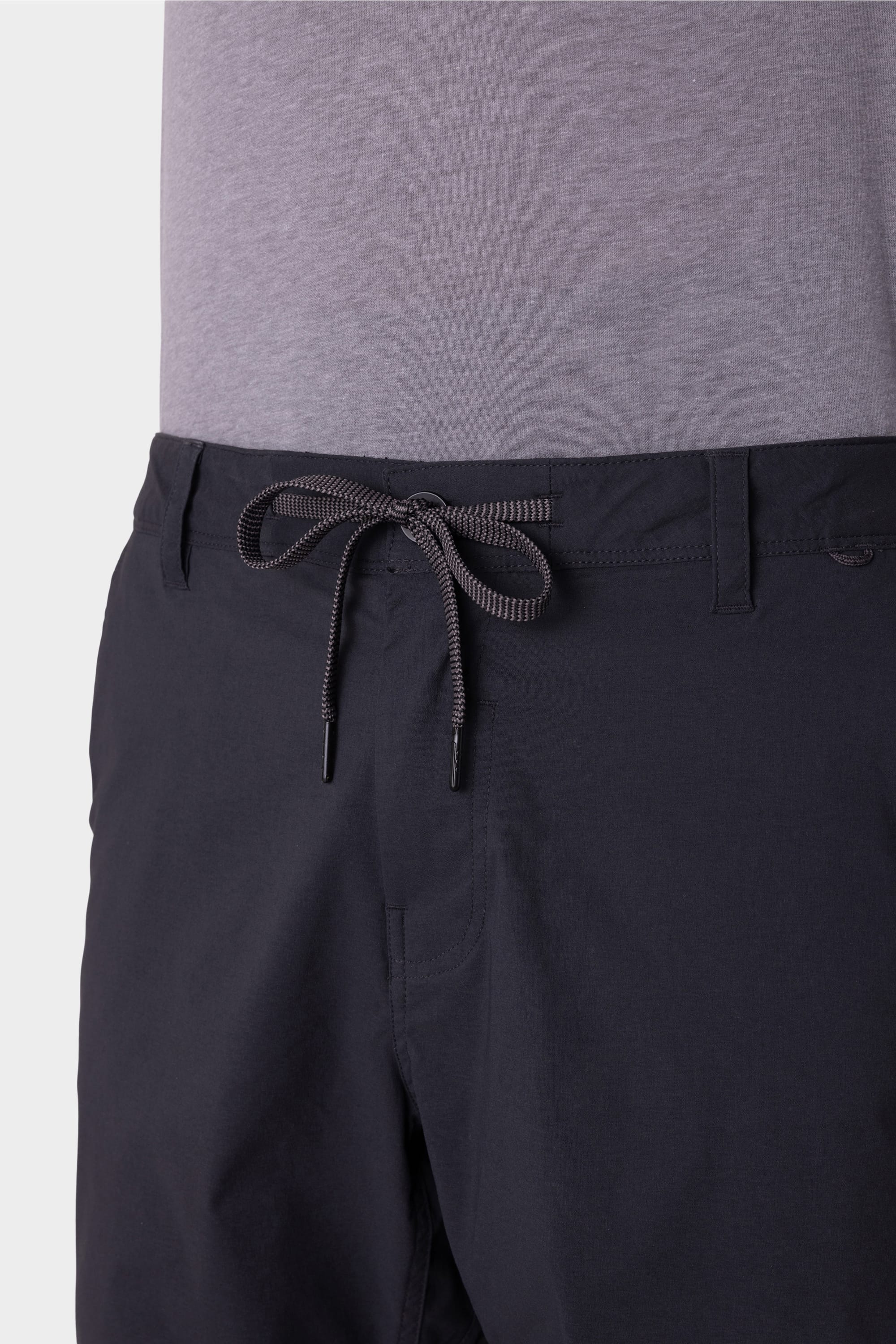 A person wears a light gray t-shirt with 686 Men's Everywhere® Featherlight Chino Shorts, featuring an adjustable drawstring waistband, belt loops, and a breathable design. The image highlights the shorts' waist and upper legs. Brand: 686.