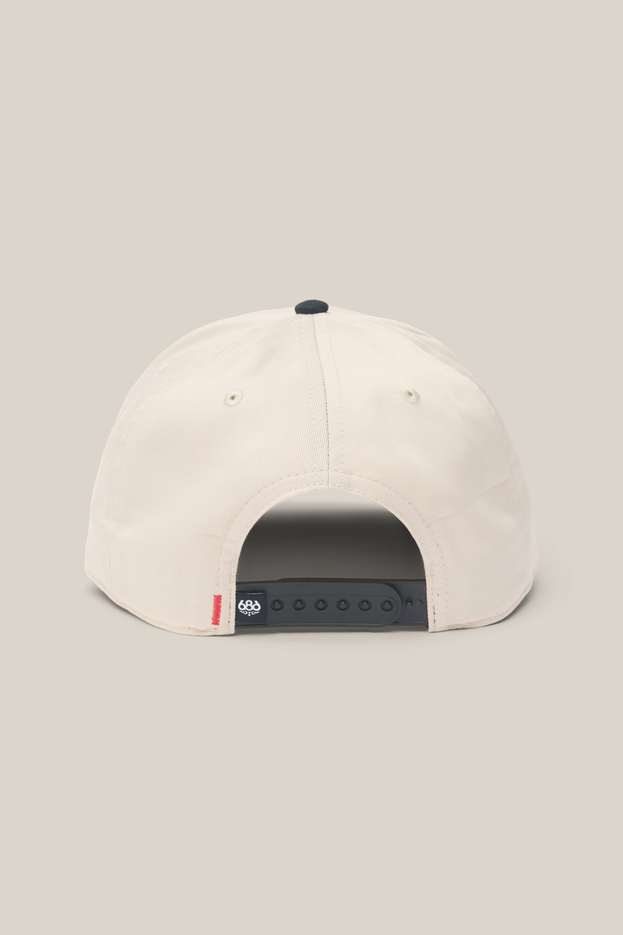 The 686 High-Pro Ses Two Tone Structured 5 Panel Hat by 686 is a beige men‚Äôs hat shown from the back, with a black adjustable snapback strap and a small red tag on the left above the strap, made from 100% cotton, set against a neutral background.