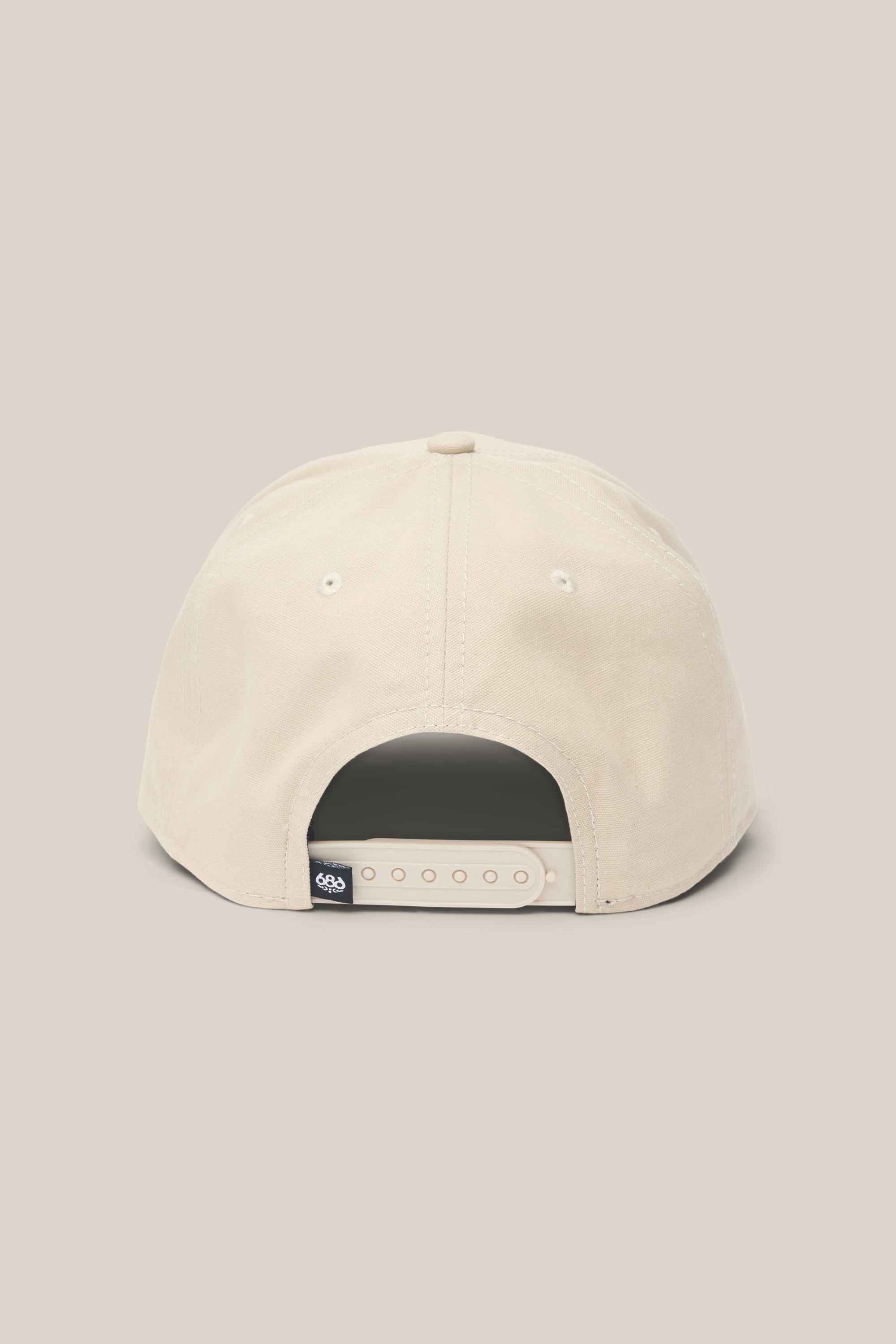 The 686 High-Pro 92 Structured 5 Panel Hat by 686 in beige polyester-cotton is shown from the back, displaying its adjustable snapback strap and a small black tag on the left. The background matches the hat’s beige color.