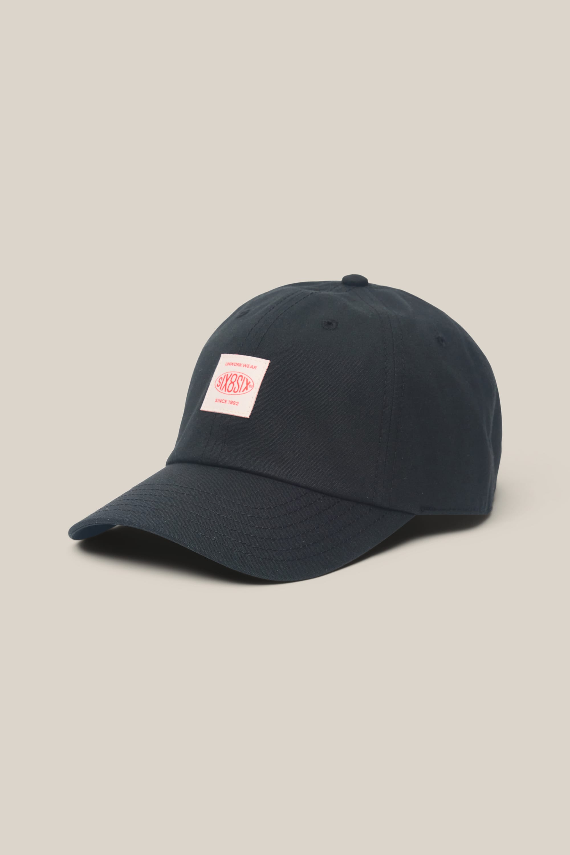Certainly! Here’s the rewritten sentence using your product data: The 686 Low-Pro Unwork Unstructured 6 Panel Hat by 686 is a black men's hat with a curved brim and a white rectangular patch featuring red text on the front, crafted from a comfortable polyester cotton blend and displayed against a plain beige background.