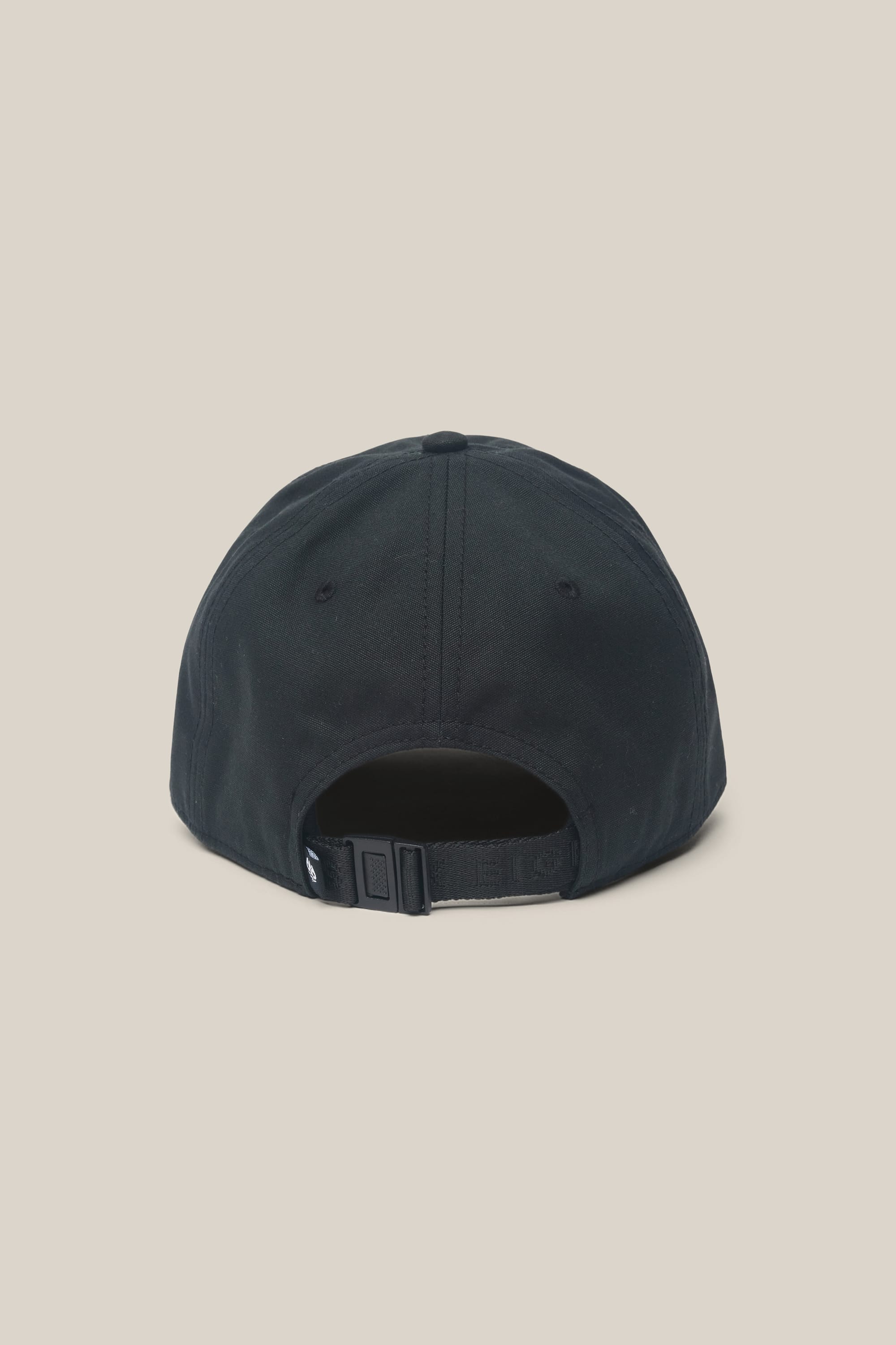 The 686 Low-Pro Unwork Unstructured 6 Panel Hat by 686 is a black men's polyester cap shown from the back, with an adjustable strap and a curved opening above it, set against a plain beige background.