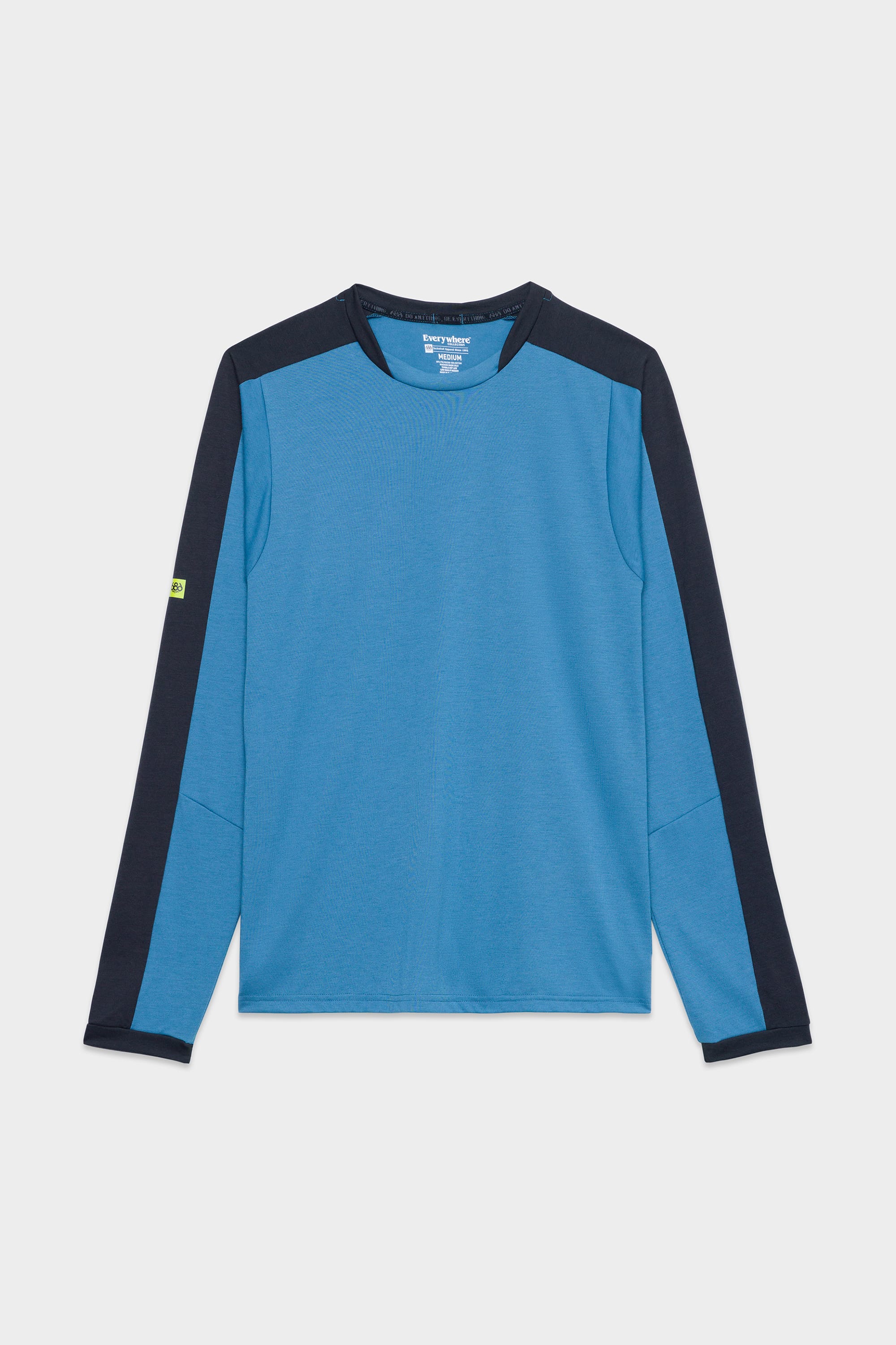 The 686 Mens Rival Long Sleeve Bike Jersey by 686 features a light blue front and back, dark navy sleeves and shoulder panels, plus a small green logo on the left sleeve. It is displayed laid flat on a white background.