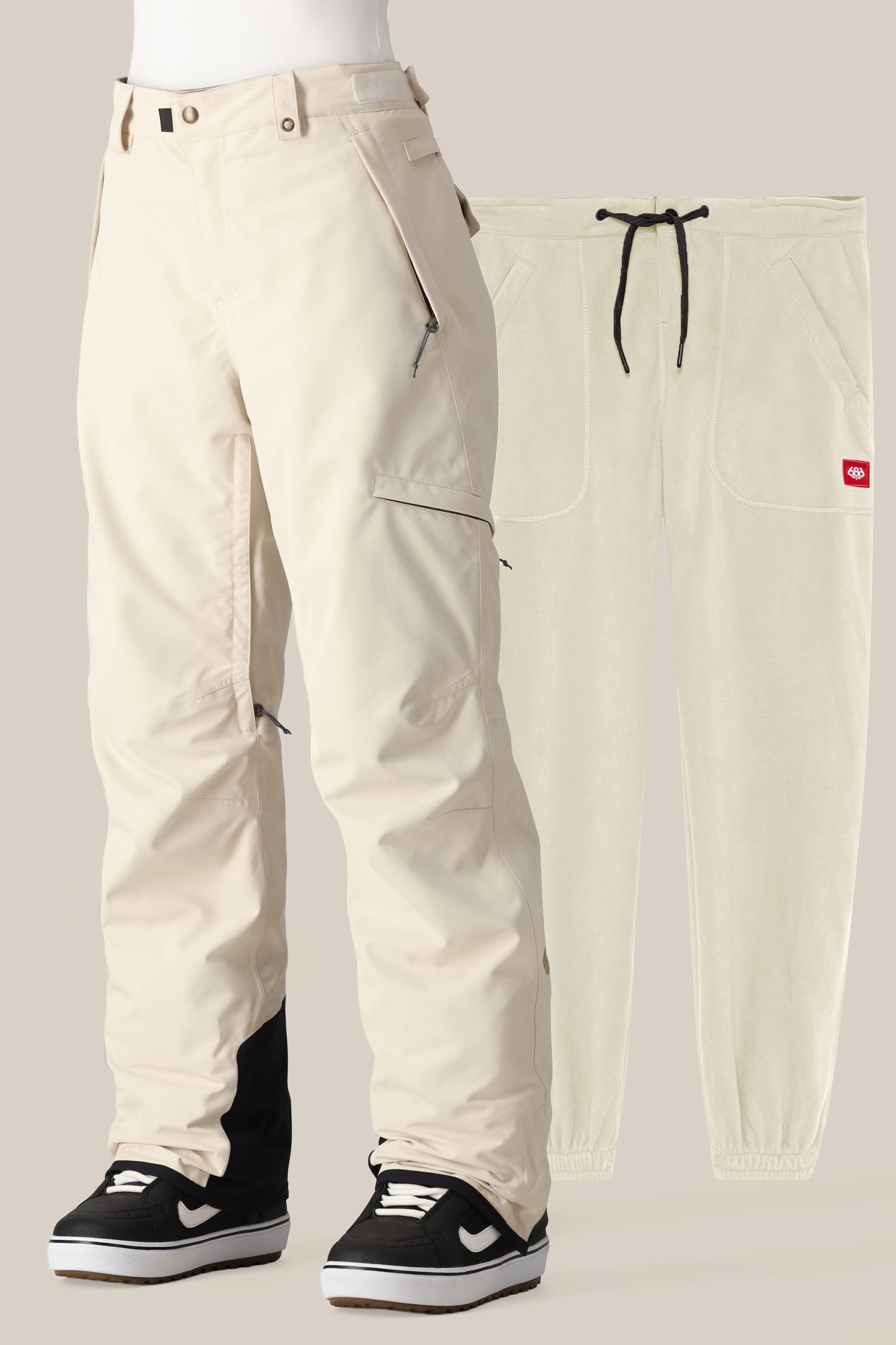 The 686 Women's SMARTY® 3-in-1 Cargo Pant by 686 is shown in cream with black ankle cuffs, zippered pockets, and a removable liner, styled over black-and-white sneakers and paired with matching cream jogger pants for versatile wear.