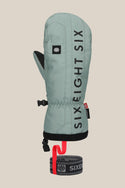 The 686 Mens Team Merino Mitt is a sage green winter mitten featuring black vertical SIX EIGHT SIX text, a small logo patch, black trim, internal finger separation for warmth, and an attached black-and-red wrist leash.