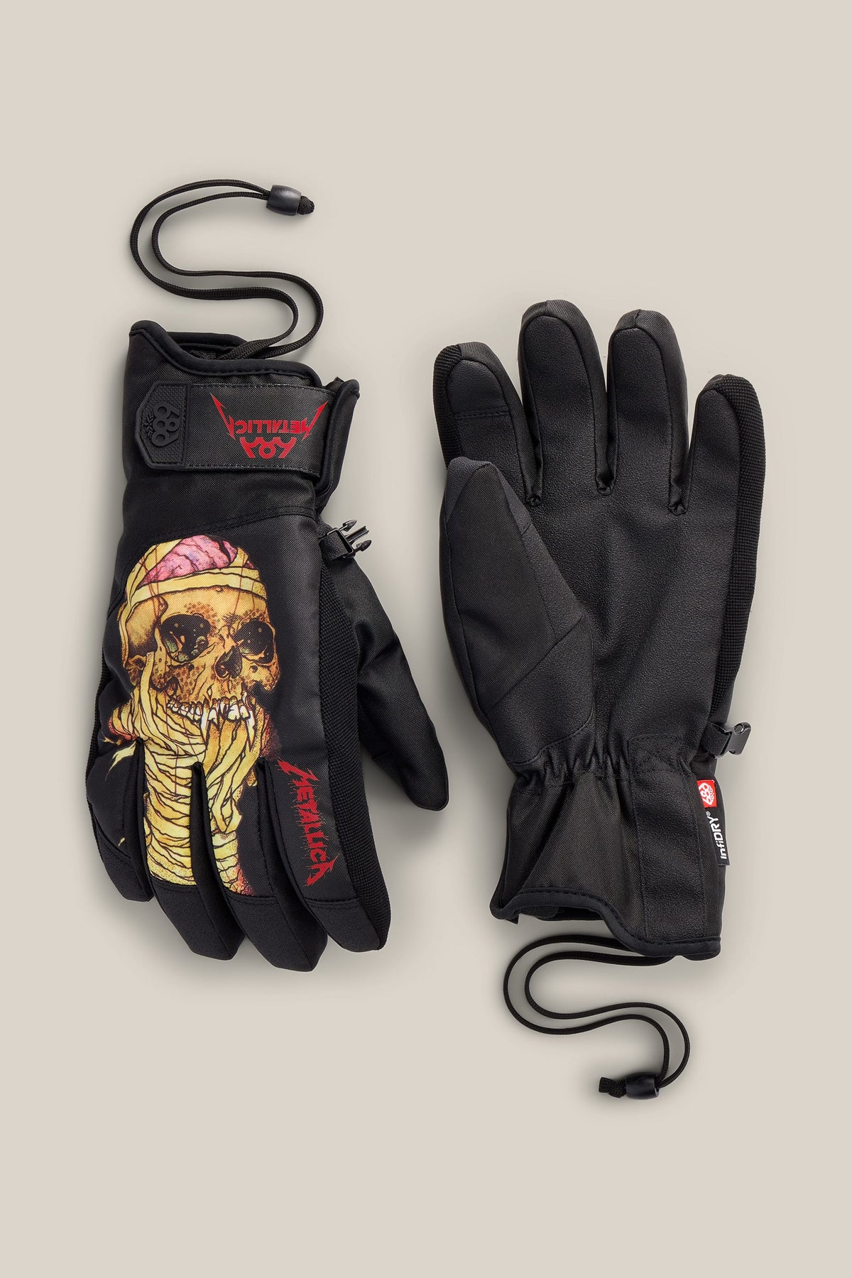 A pair of black 686 Men’s Primer Glove snow gloves featuring a graphic of a mummy skull and the Metallica logo on the back of the left hand.