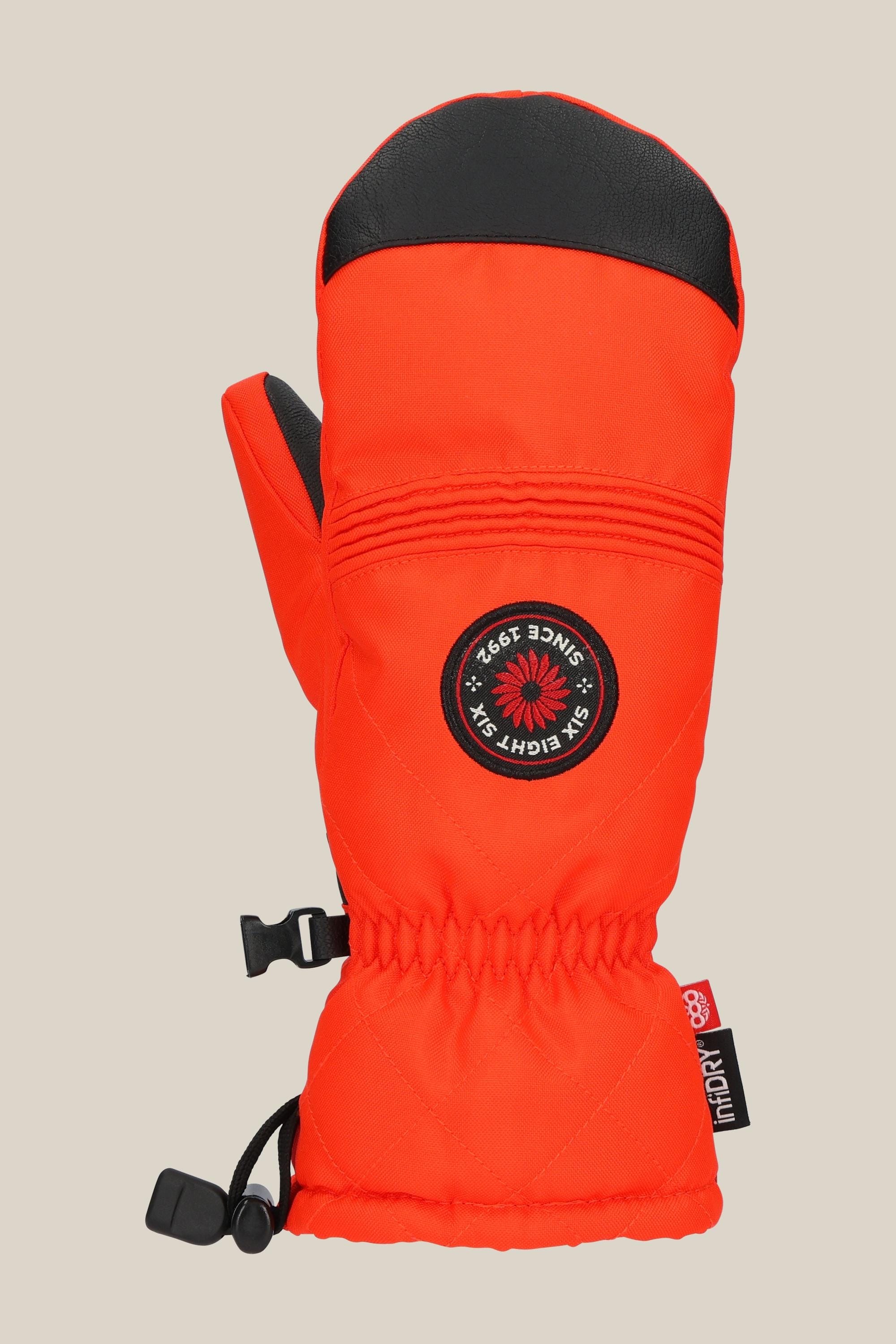 The 686 Women's Jubilee™ Mitt by 686 is a bright red, waterproof mitten with black accents, featuring an embroidered circular SKI EIGHT-FIX SINCE 1982 patch, light insulation, adjustable wrist strap, and a small black side clip.