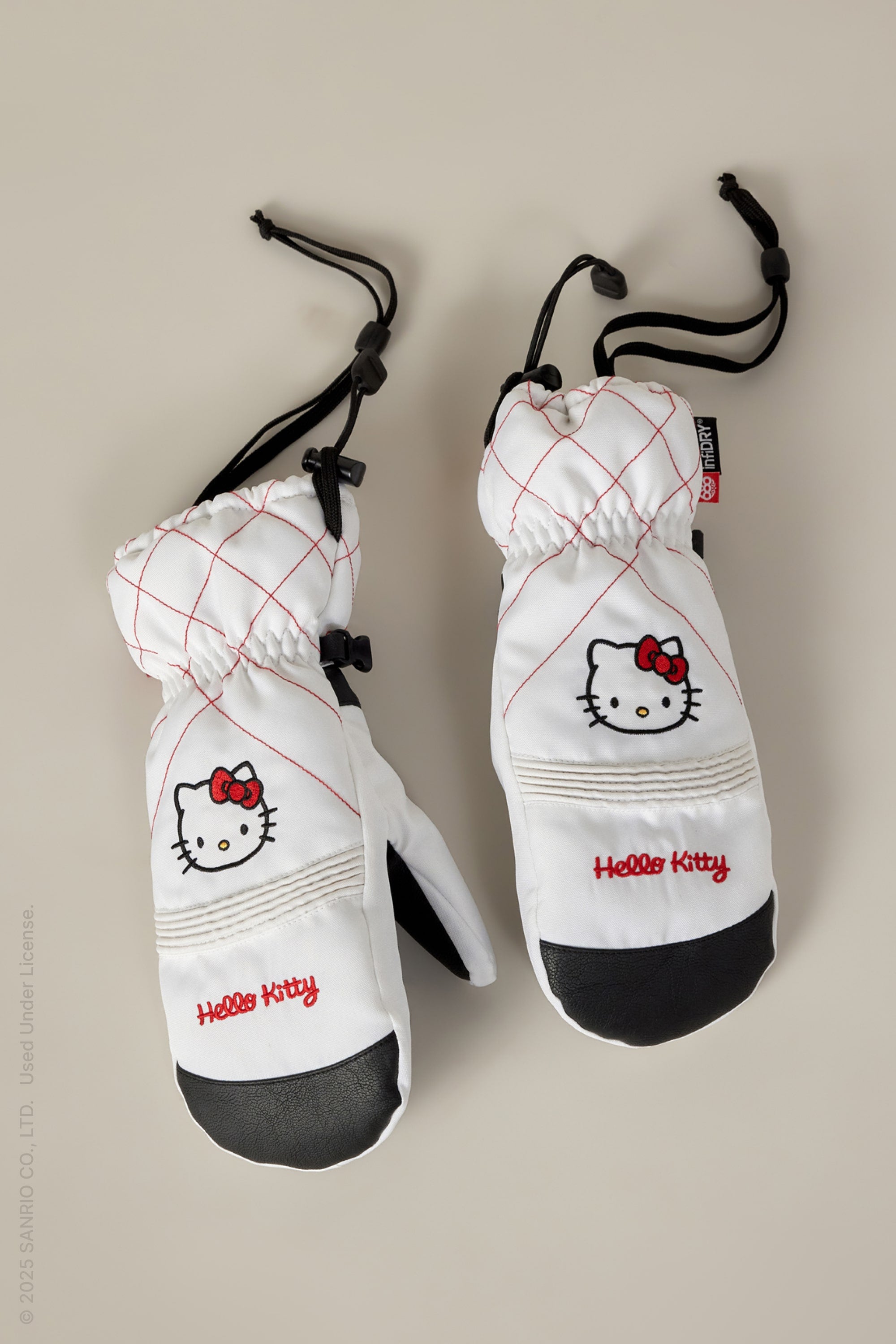 The 686 Women's Jubilee™ Mitt by 686 features white fabric with red stitching, black palms, Hello Kitty embroidery, a red bow, adjustable drawstrings, and light insulation for warmth and dryness.