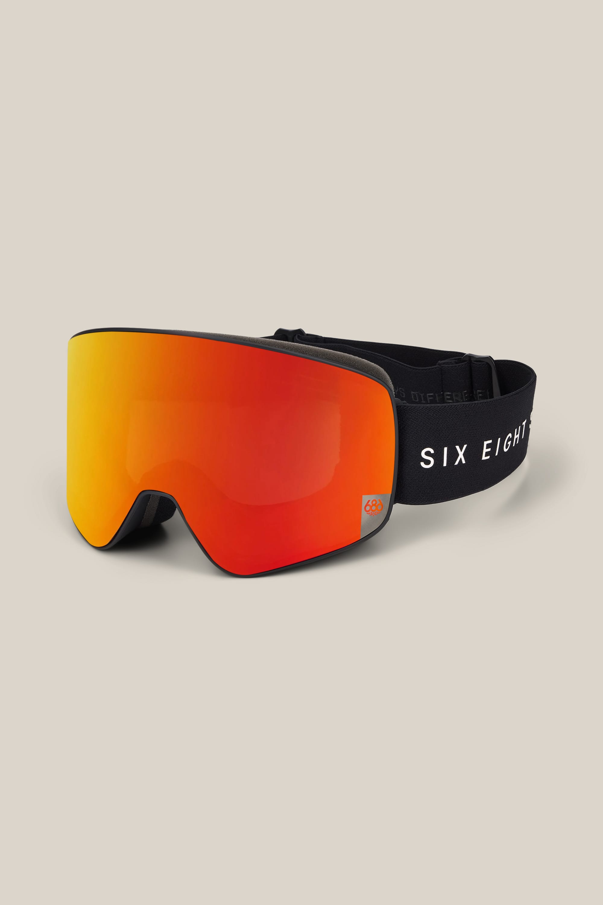 The 686 SMARTY® Magnetic Goggle by 686 features a reflective orange-red lens and a black adjustable strap bearing the SIX EIGHT logo. The goggles are set against a plain beige background.