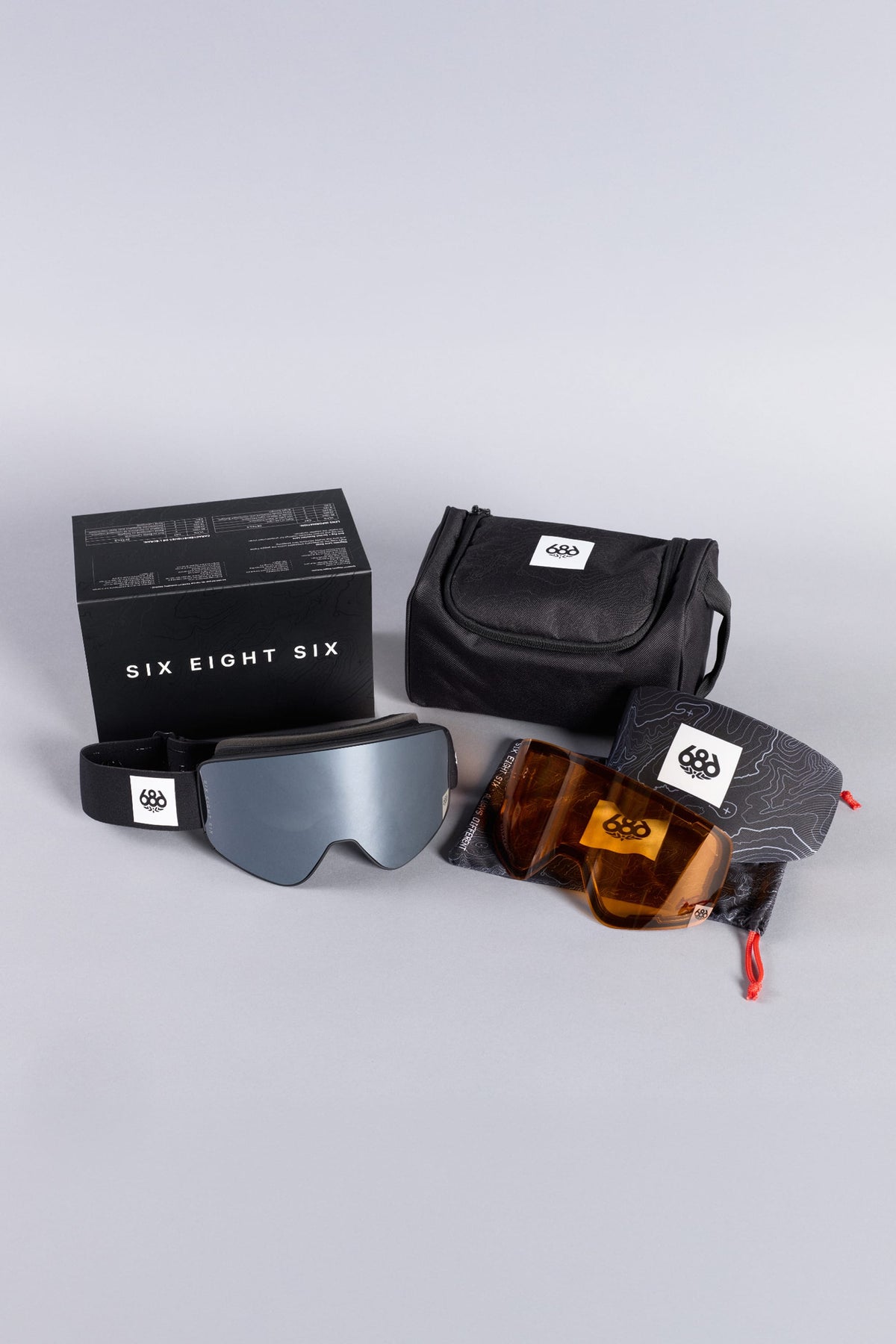 686 SMARTY® Magnetic Goggle featuring an oversized strap, a mirrored lens, an additional orange lens, a carrying case, a storage pouch, and a branded product box.
