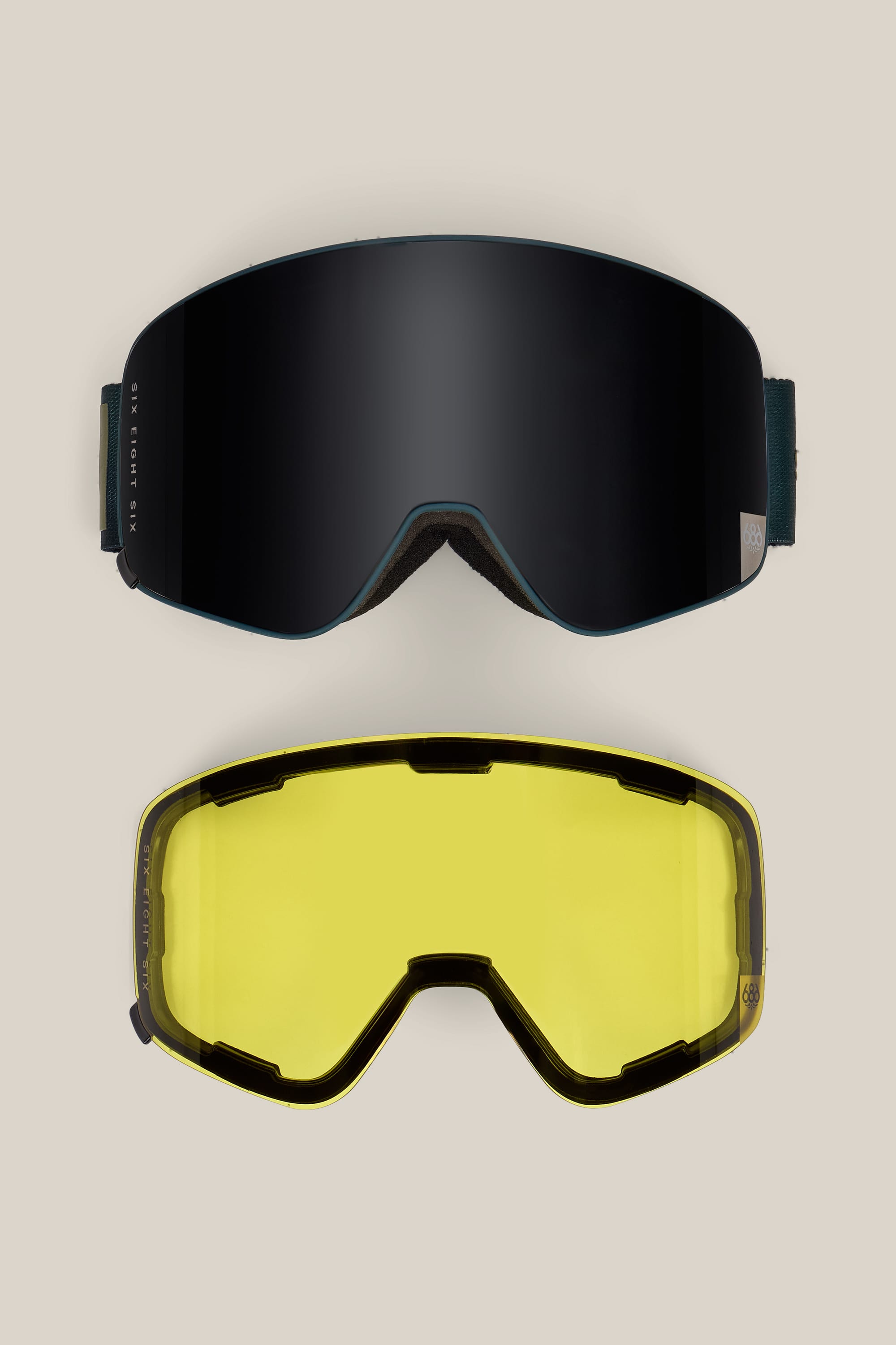 Two 686 SMARTY® Magnetic Goggles by 686 are displayed against a plain, light background: the top features a dark, reflective lens, while the bottom showcases a yellow-tinted lens.