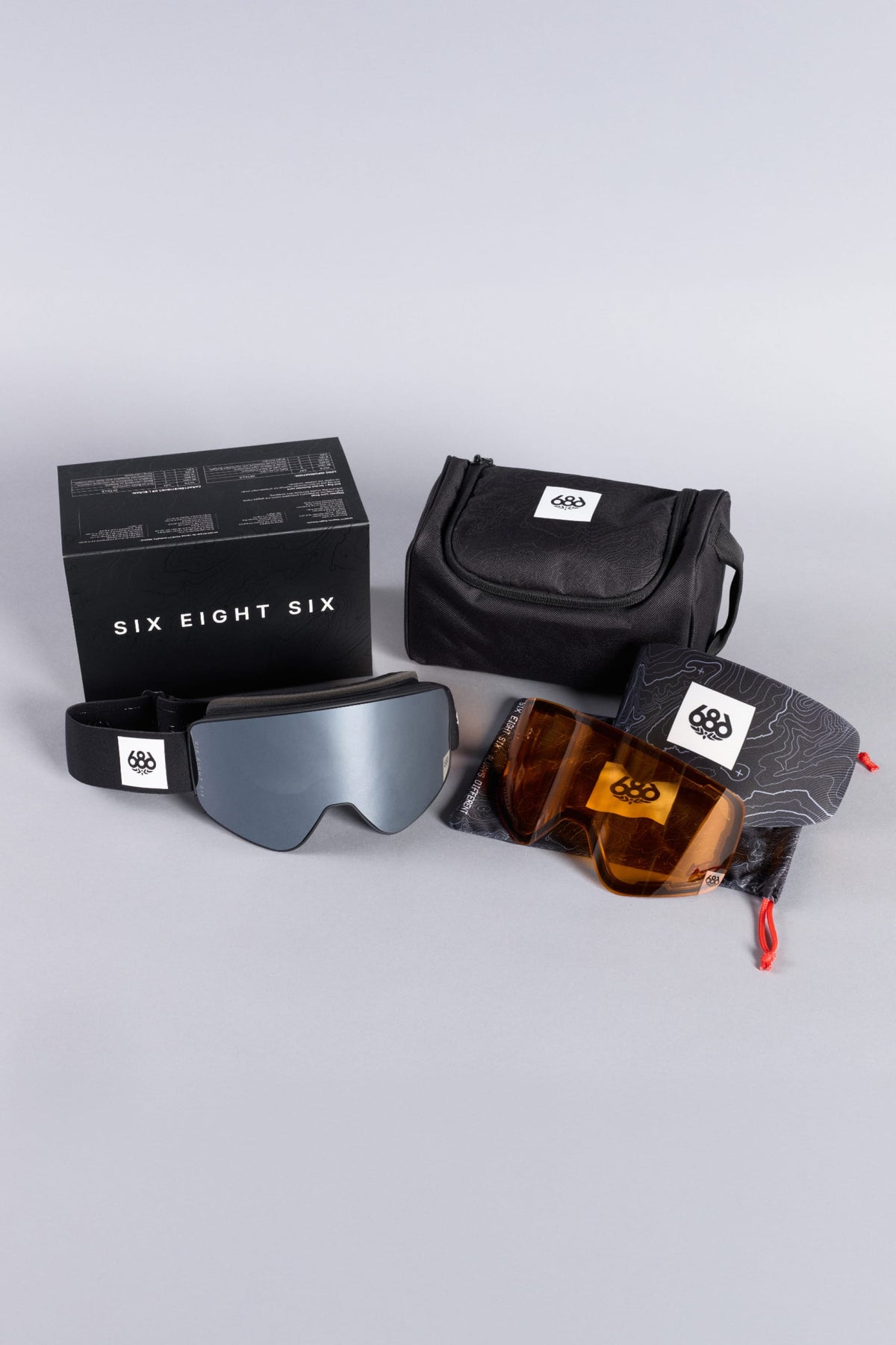 A set of 686 SMARTY® Magnetic Goggles with interchangeable lenses, a black carrying case, a storage pouch, and a black branded box displayed on a light gray surface.
