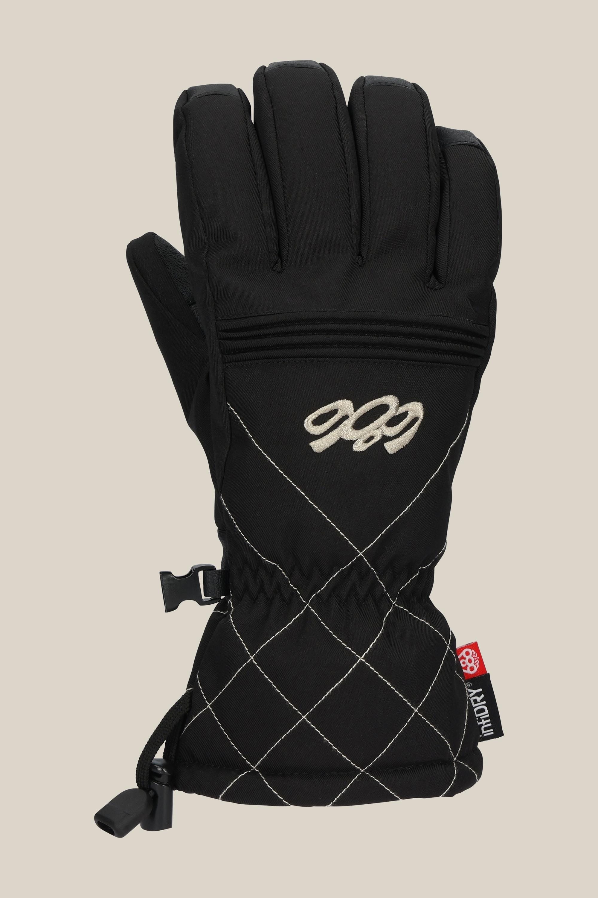 The 686 Women's Jubilee™ Glove by 686 is a black poly glove with white diamond-pattern stitching, a zip pocket on the back, "CCC" embroidered in white, a red and black tag by the wrist, plus drawstring and clip.