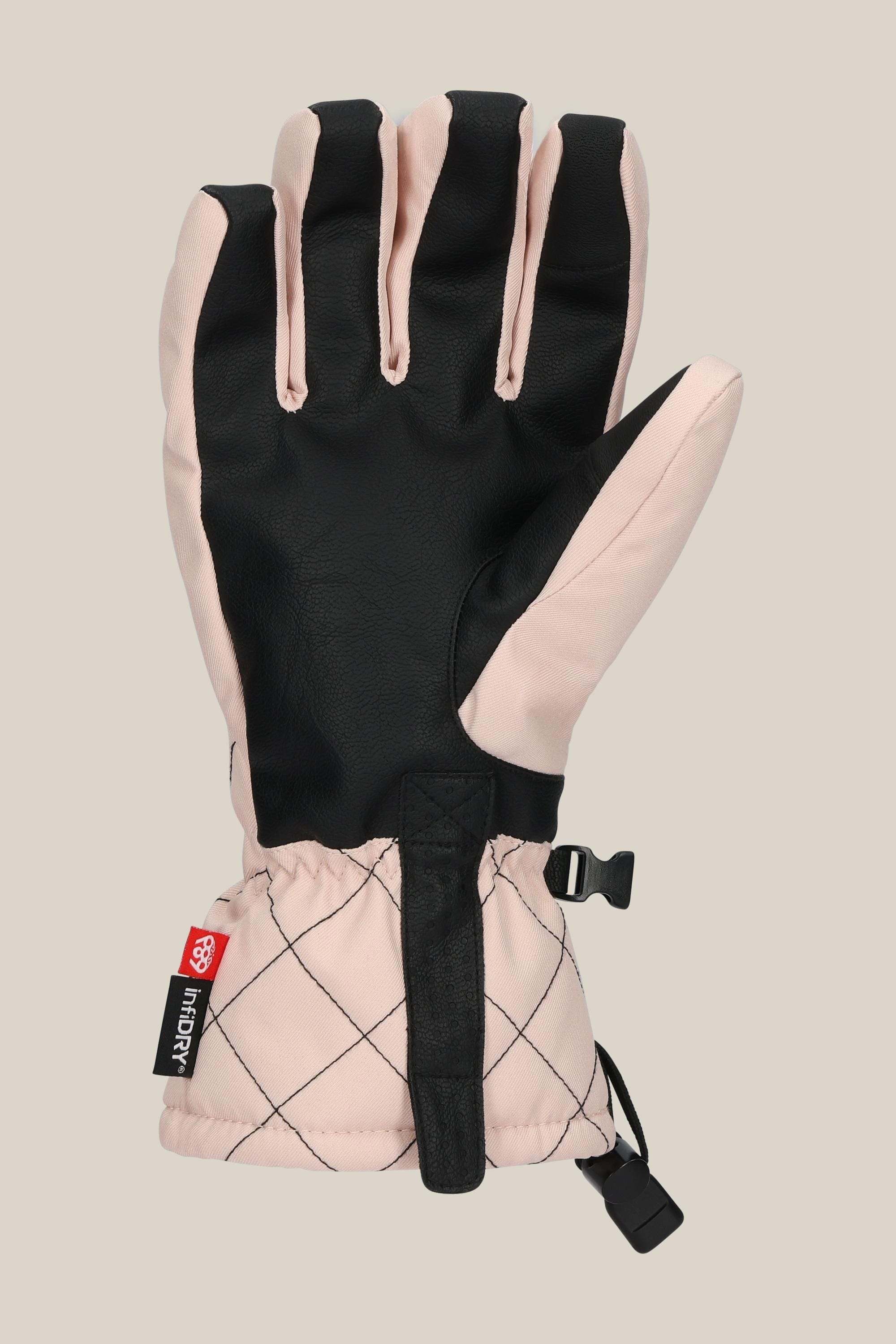 The 686 Women's Jubilee™ Glove features a black palm, light pink top, diamond-quilted cuff, adjustable strap, and a small red and black 686 tag. This insulated PU glove is shown palm up.
