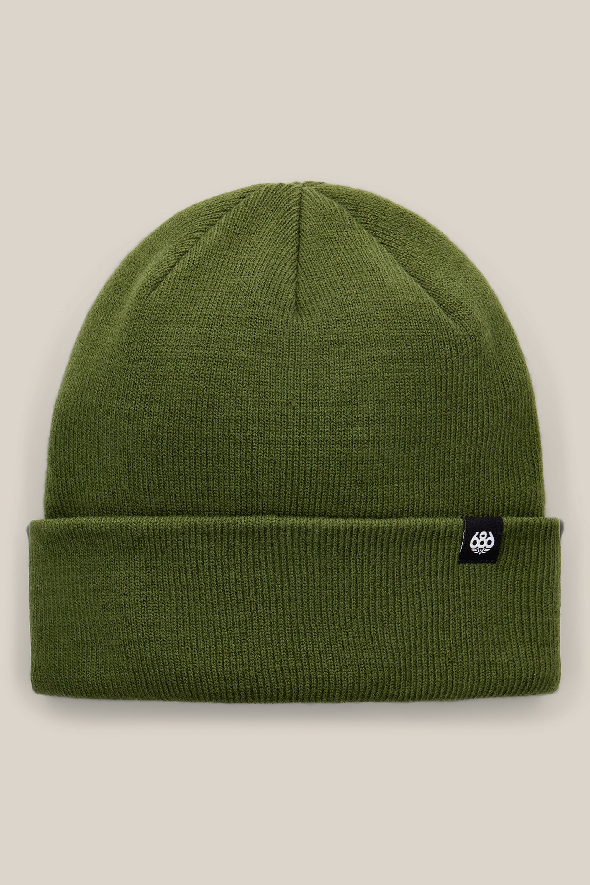 The 686 Standard Roll Up Beanie by 686 is a plain olive-green knit beanie with a folded brim, featuring a small black tag with a white logo on the side, displayed against a neutral beige background.