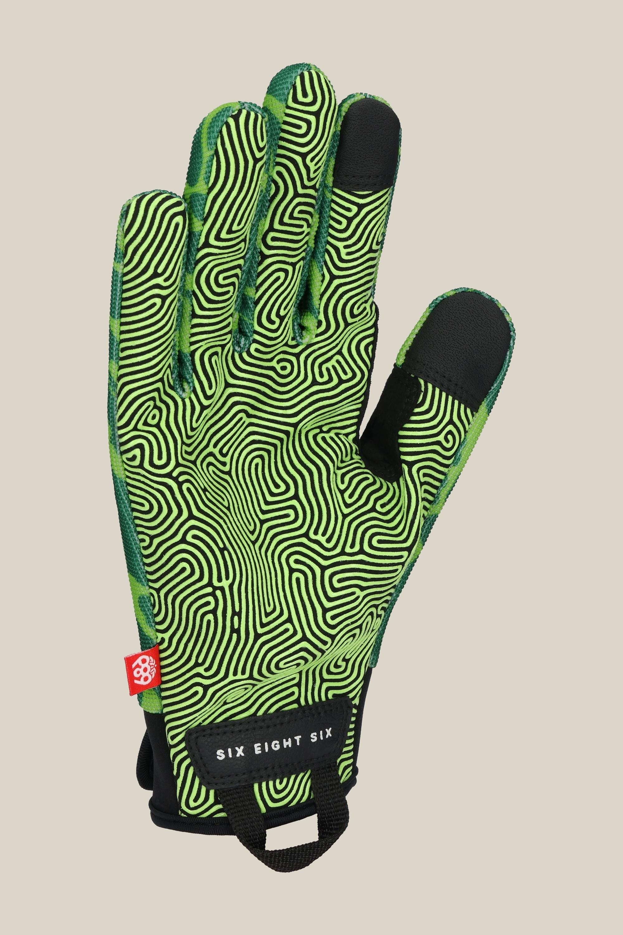 The 686 Outlaw Pipe Glove by 686 is shown palm up. It features a green design with black maze-like swirls, black tips on the thumb and index finger, a red tag, and a black wrist loop labeled "SIX EIGHT SIX.