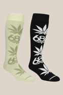 Two knee-high 686 Men's HUF Socks are shown: one light yellow with a gray cannabis leaf and '68' design, the other black with a white leaf and '68', both displayed on a plain beige background.