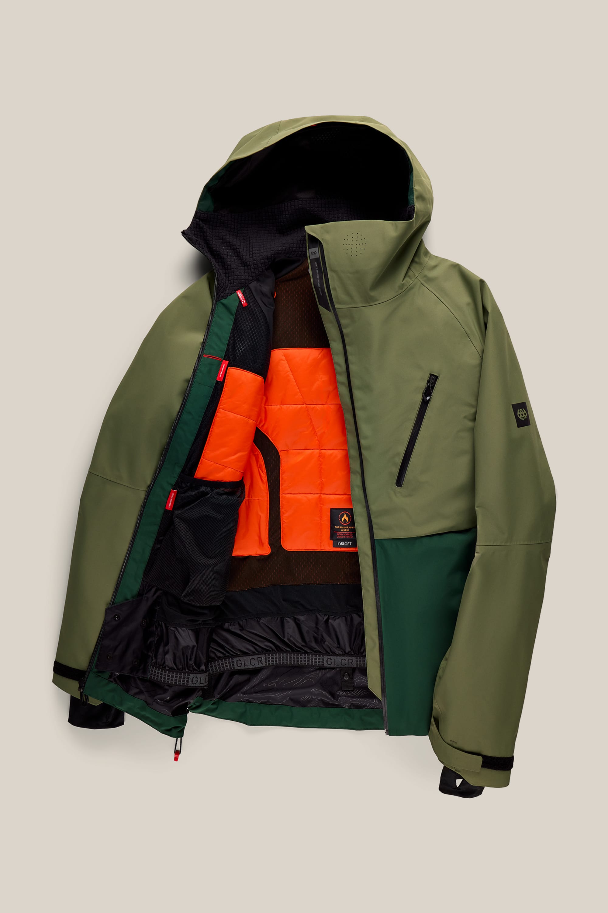 The 686 Men’s Hydra™ Thermagraph® Jacket by 686 is a green winter coat featuring a hood, black zipper, chest pocket, and a bright orange quilted lining. The jacket is displayed open and laid flat on a light beige background.