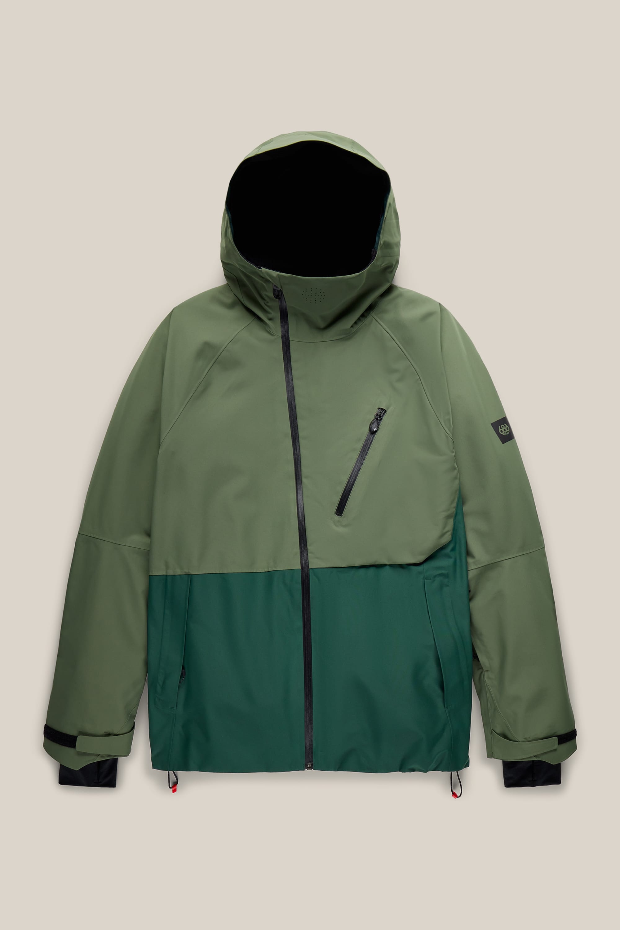 The 686 Men’s Hydra™ Thermagraph® Jacket by 686 is a two-tone green hooded jacket featuring a diagonal zippered chest pocket, side pockets, black wrist cuffs, and a front zipper, displayed on a plain beige background.