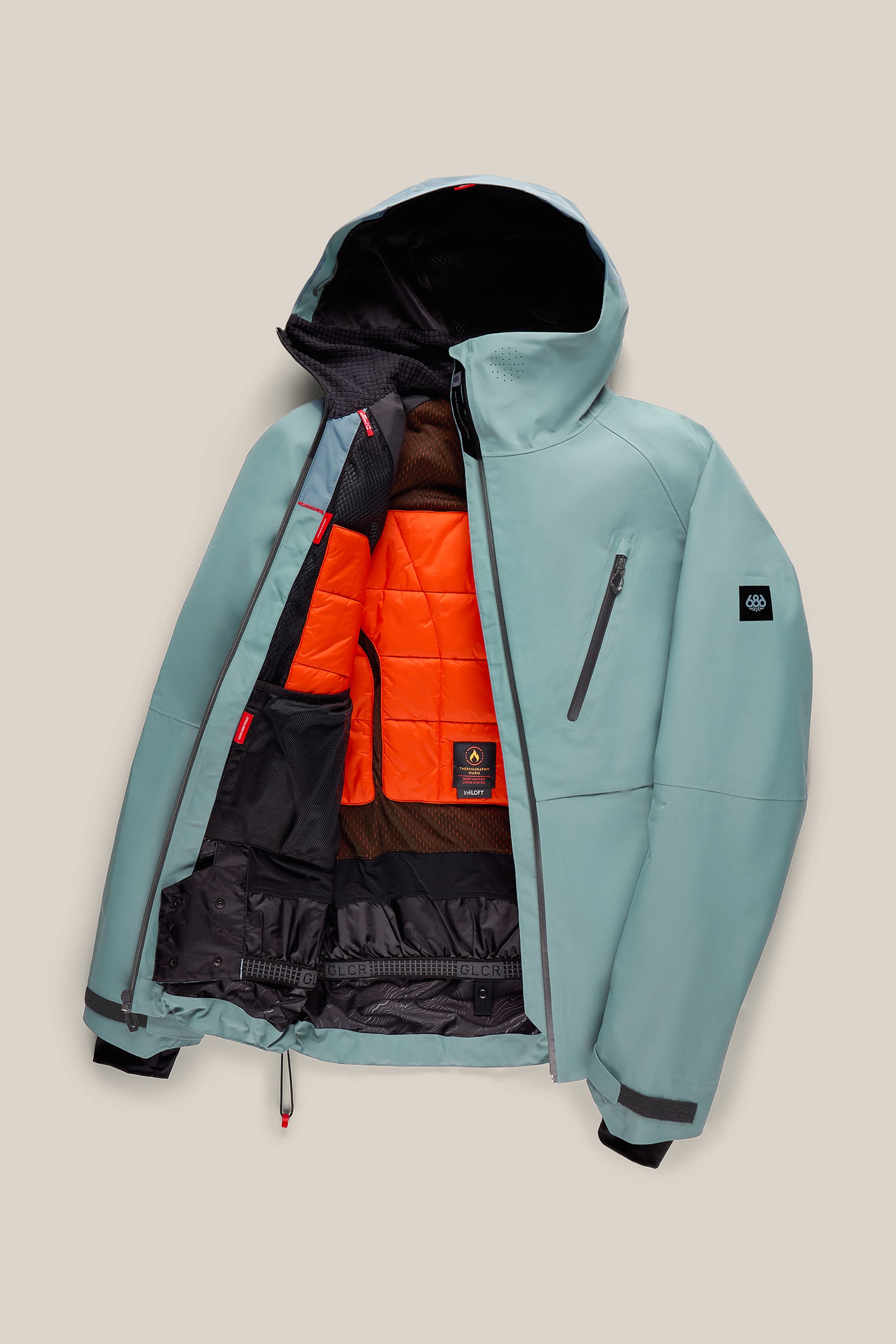The 686 Men’s Hydra™ Thermagraph® Jacket by 686 features a light blue color with a black zipper, chest pocket, and an eye-catching orange and black inner lining. The jacket is shown partially unzipped to highlight its insulated interior and adjustable drawstrings at the hem.
