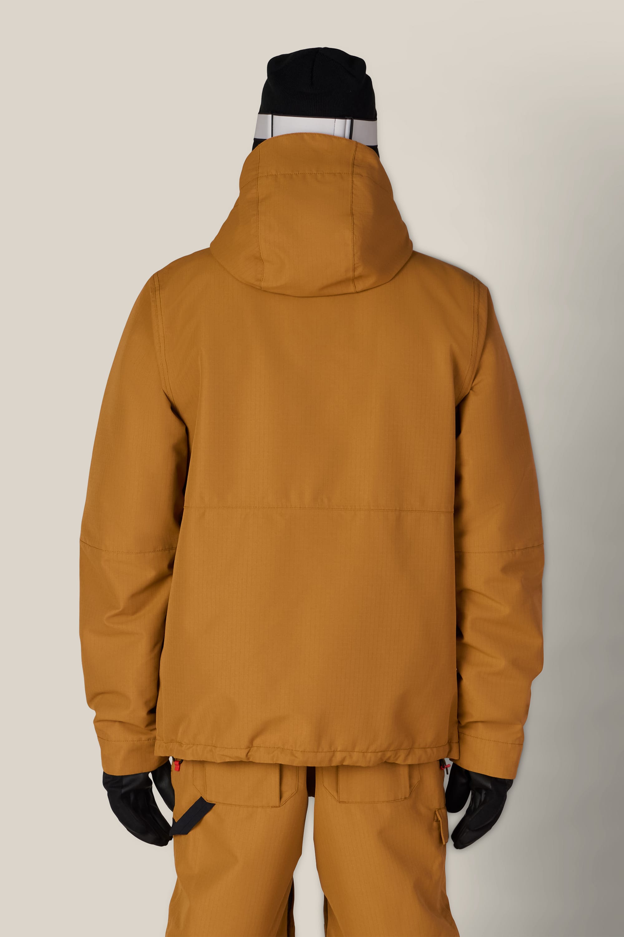 A person, seen from the back against a plain light background, is wearing the 686 Men’s Foundation™ Insulated Jacket in mustard yellow with matching pants, black gloves, and a black beanie.