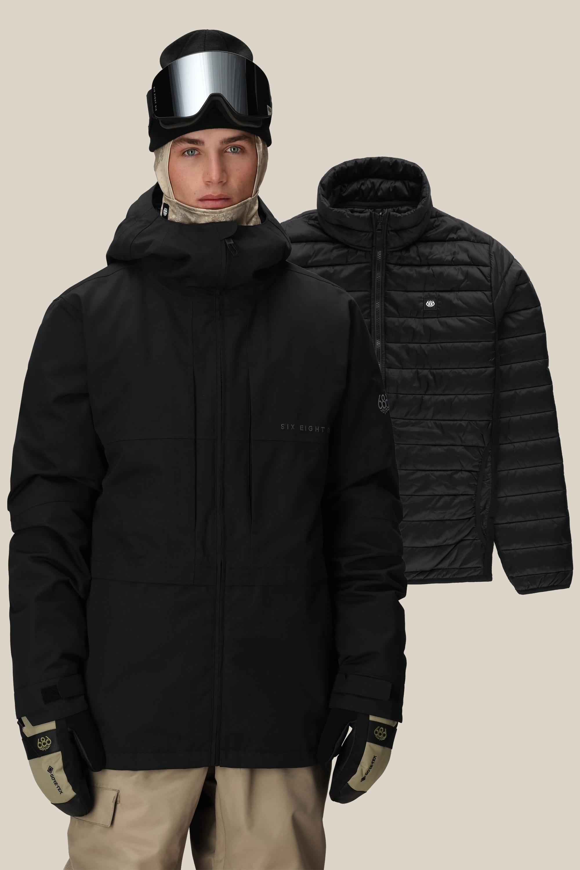 A person wears ski gear in black and beige, including gloves, a balaclava, goggles, and a hood. Behind them is the 686 Men's SMARTY® 3-In-1 Form Jacket by 686—a stylish polyester waterproof men's woven jacket on a plain beige background.