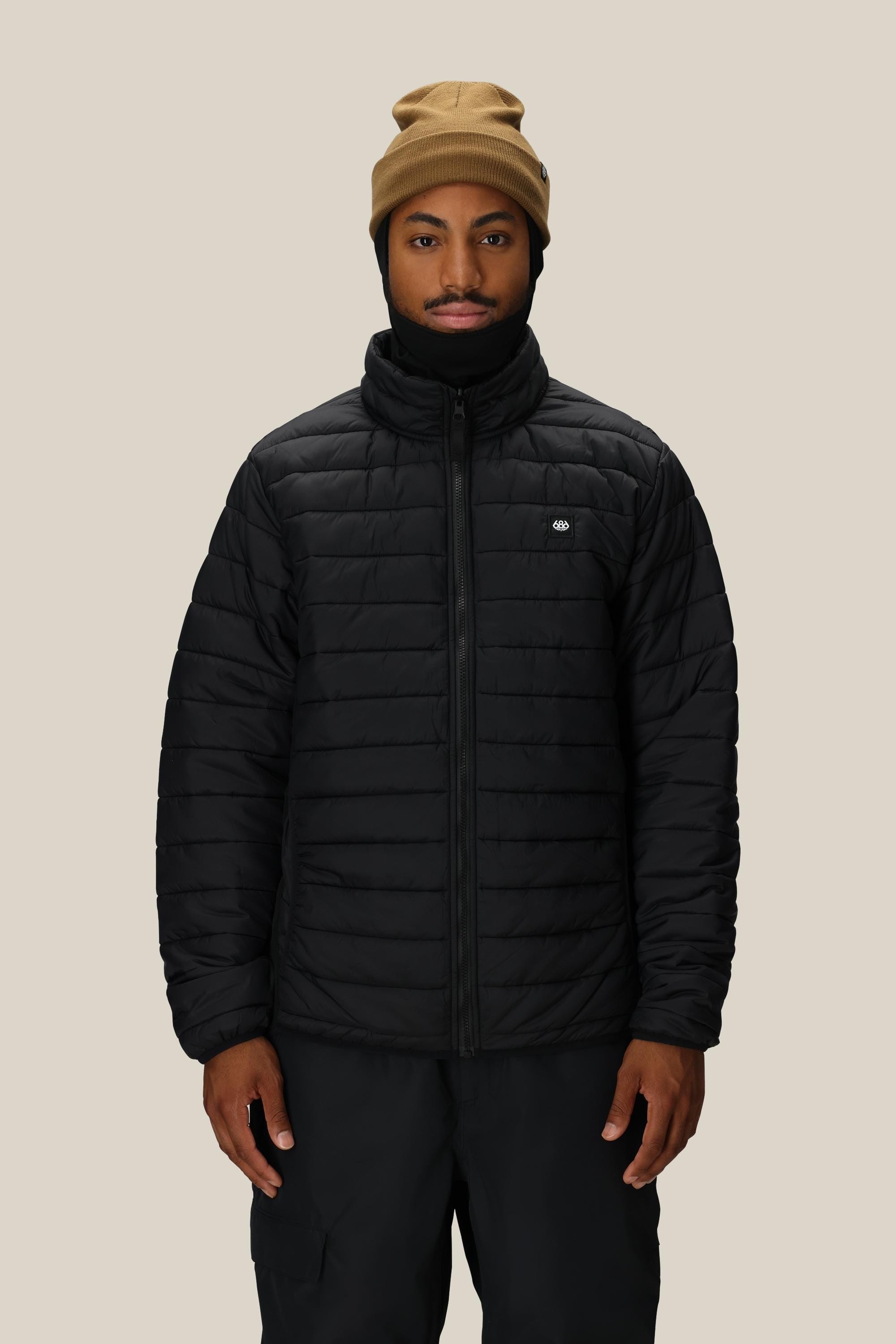 A person wearing a tan beanie and the 686 Men's SMARTY® 3-In-1 Form Jacket stands against a plain beige background, looking directly at the camera with a neutral expression.