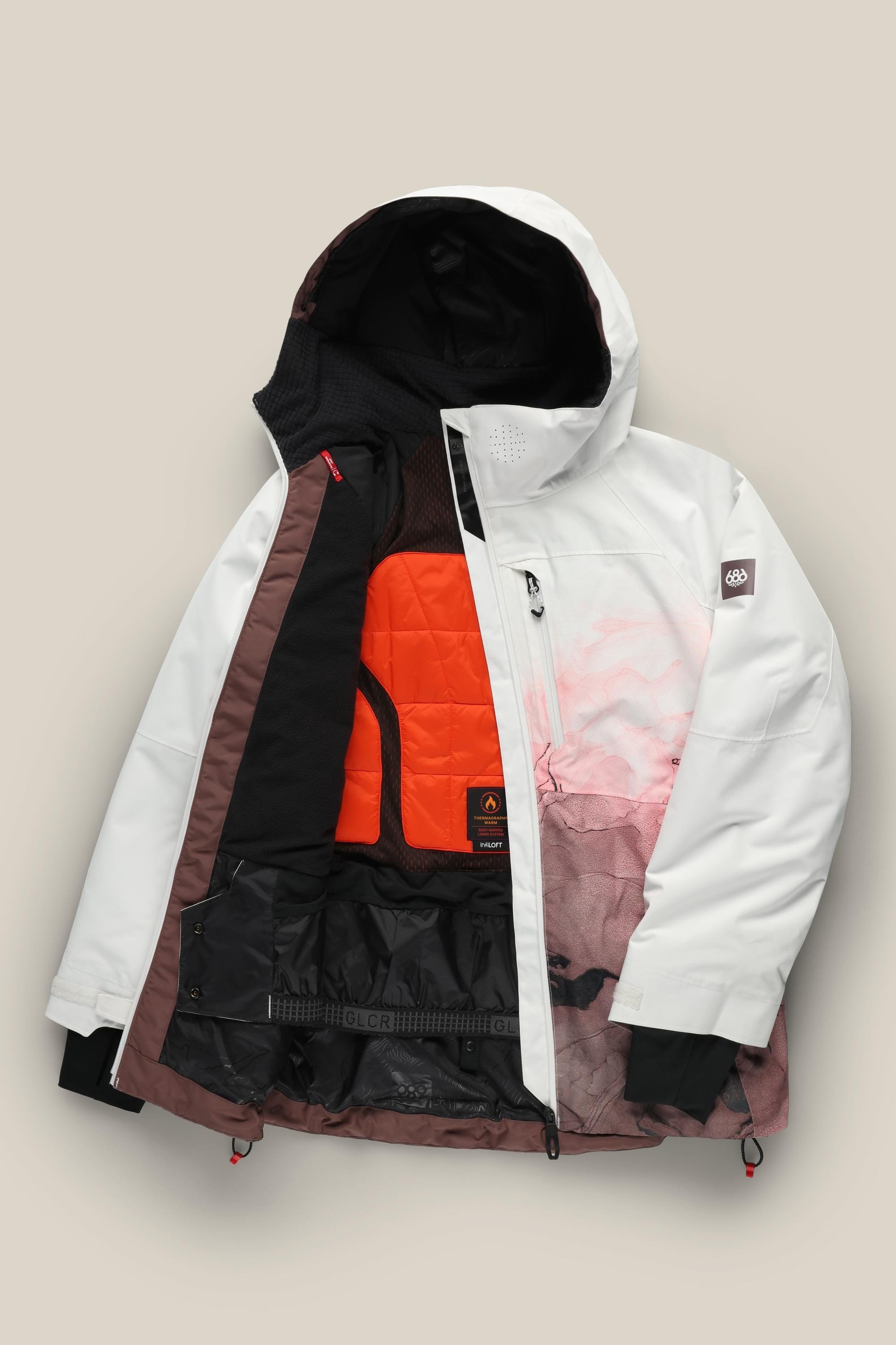 The 686 Women's Hydra™ Thermagraph® Jacket by 686 is a waterproof white and pink jacket with a hood, unzipped to show its bright orange insulated lining and multiple interior pockets, displayed against a neutral background.