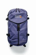 A 686 Mystery Ranch x 686 Qi 22L Snow Pack in purple with black zippers, adjustable side straps, and the 686 logo at the top center. The backpack is shown against a plain white background.