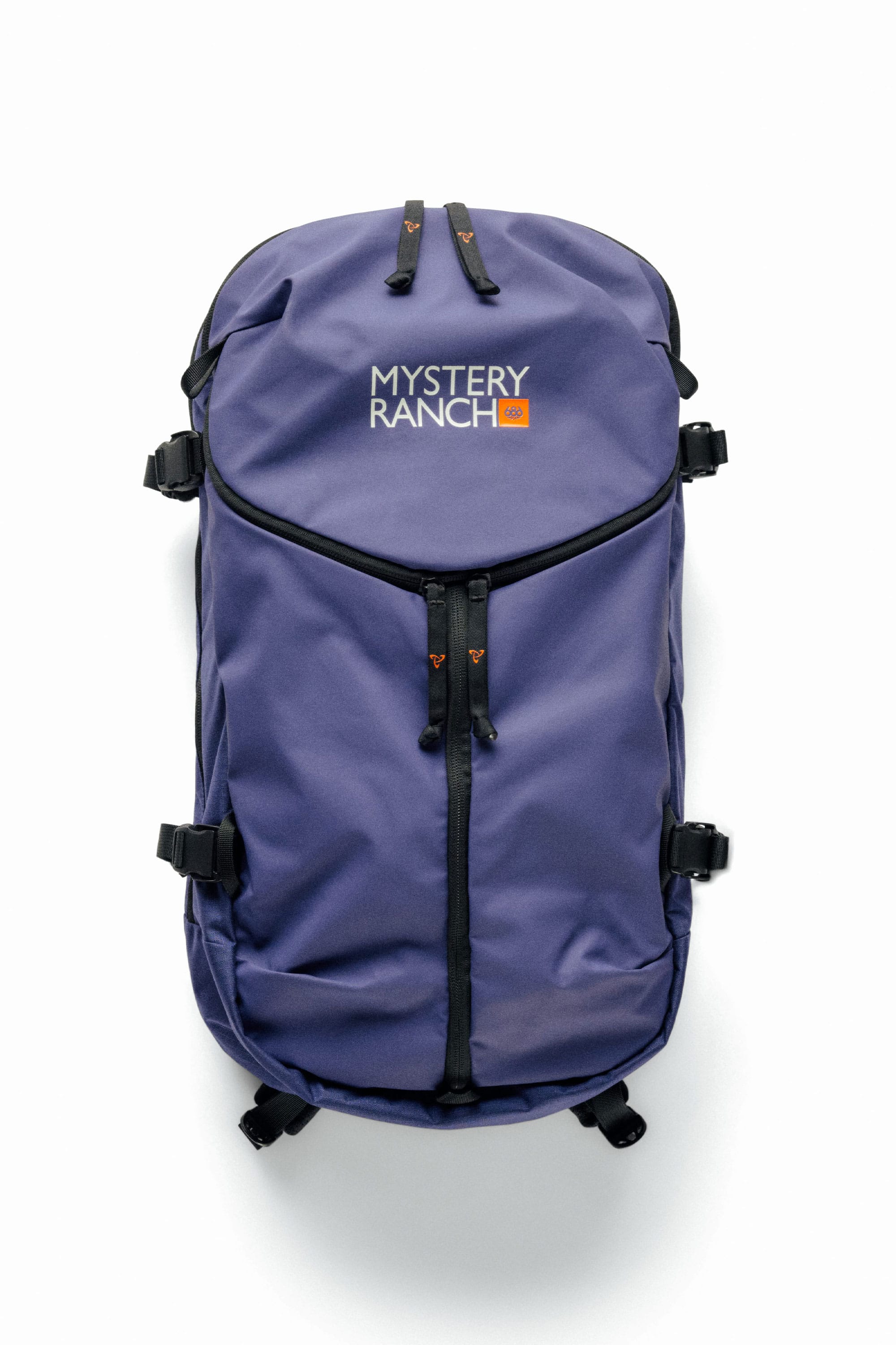 A 686 Mystery Ranch x 686 Qi 22L Snow Pack in purple with black zippers, adjustable side straps, and the 686 logo at the top center. The backpack is shown against a plain white background.