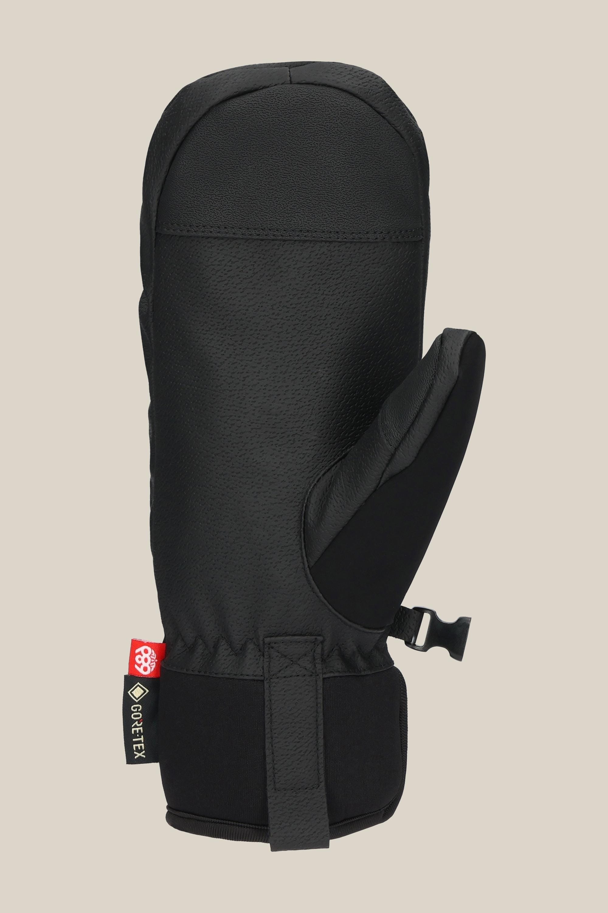 The 686 Women's GORE-TEX Linear™ Under Cuff Mitt by 686 is a black insulated mitt for women featuring a textured surface, adjustable wrist strap, and Gore-Tex label, ideal for cold weather and shown on a plain beige background.