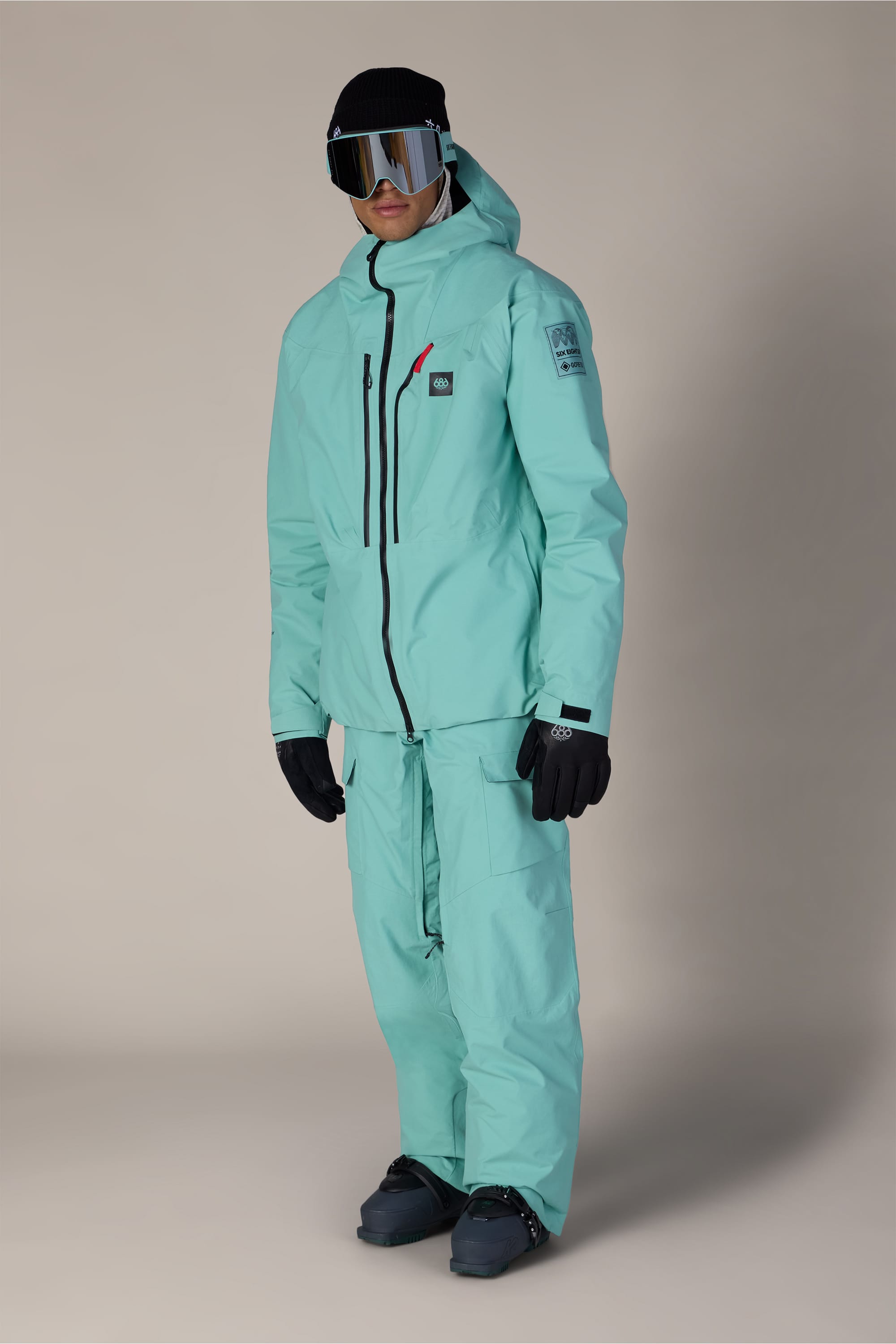 A person wearing the 686 Men’s GORE-TEX® Dispatch™ Thermagraph® Jacket stands against a plain beige background, facing slightly to the left.