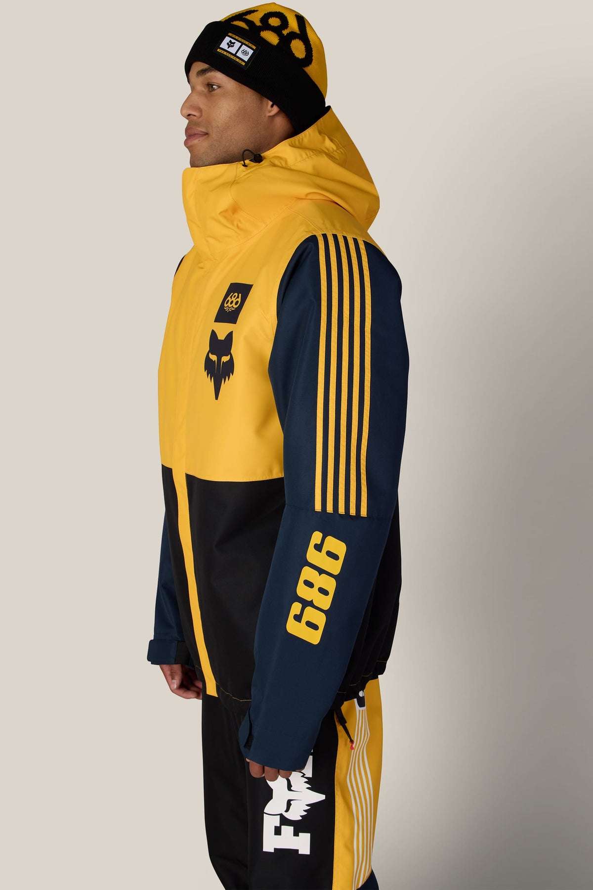 A person wearing a 686 Men’s Fox Racing Spec Insulated Jacket, matching beanie, and pants.