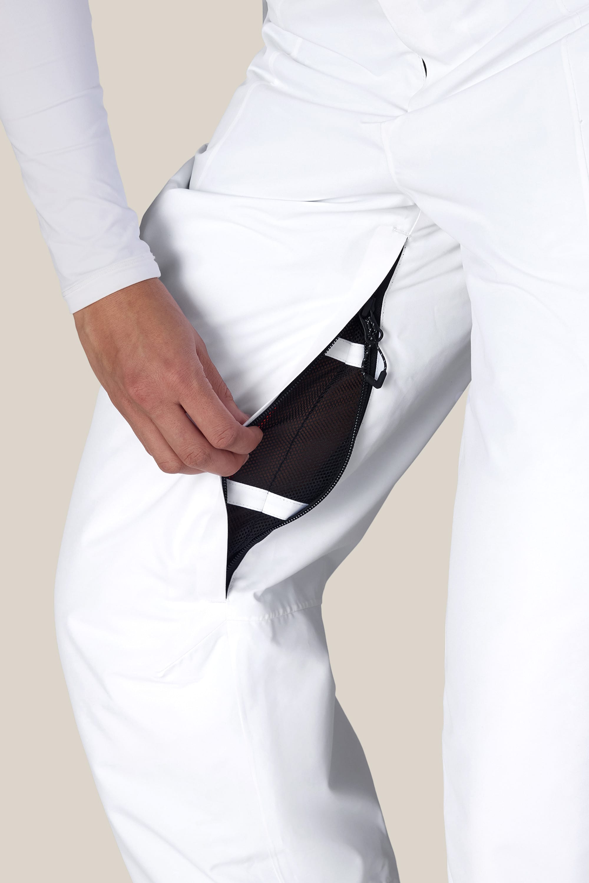 A person wearing the 686 Women’s Geode Thermagraph® Pant unzips a thigh vent, revealing black mesh fabric underneath.