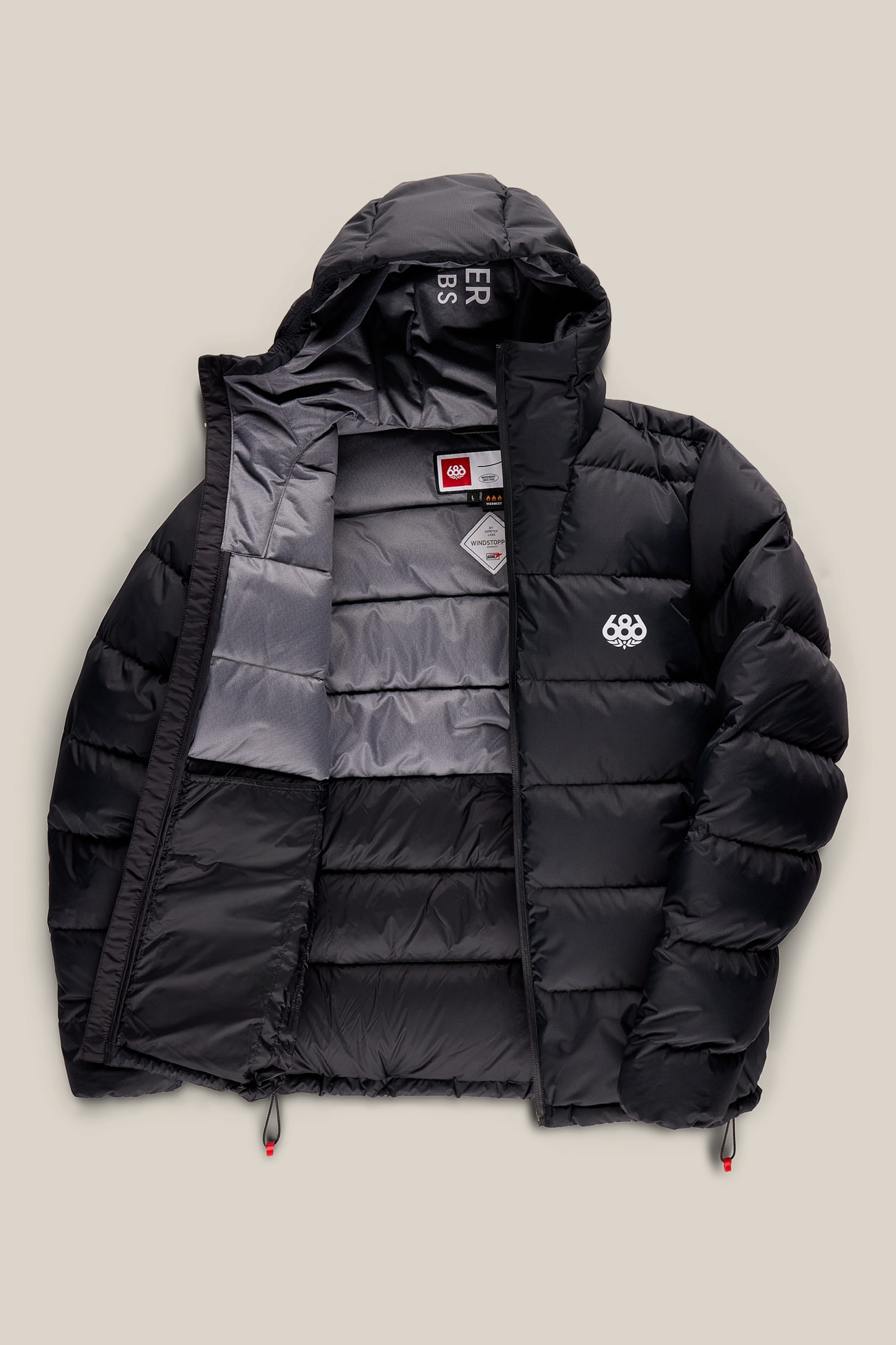 686 Men’s WINDSTOPPER® Pyro™ Down Puffer Jacket by GORE-TEX® LABS—shown partially unzipped to reveal the gray interior lining and labels. This black polyester jacket features a hood and displays a white 686 logo on the left chest.
