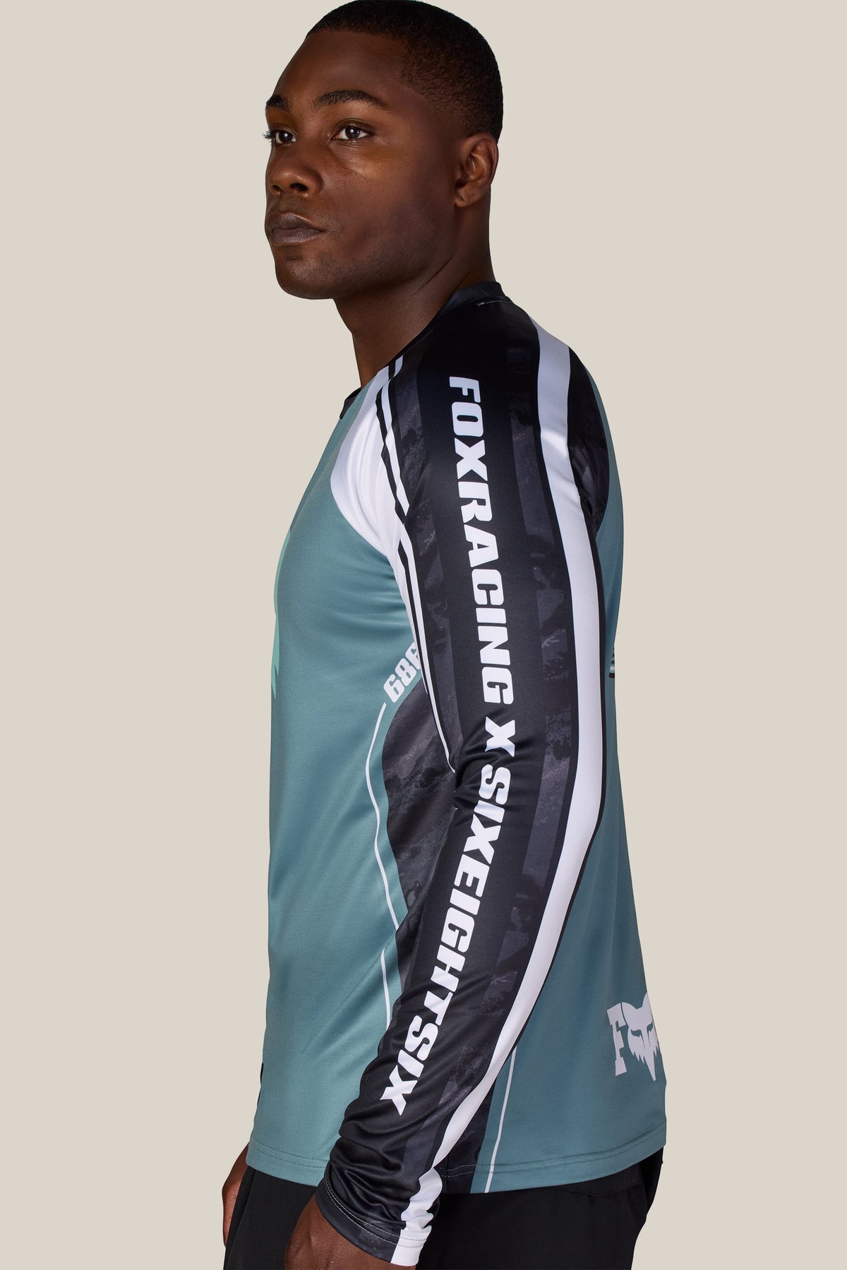 A man wearing a 686 Men’s Fox Racing Base Layer LS with the brand names printed down the sleeve.